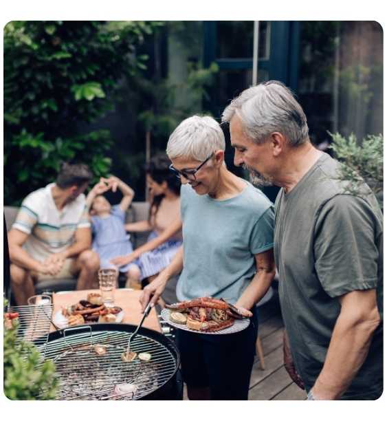 cuplu de pensionari fac gratar cu prietenii