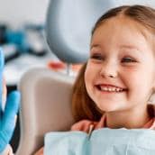 fetita care zambeste la dentistul pediatru